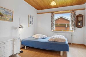 een slaapkamer met een blauw bed en een raam bij Cozy Holiday Home In Thisted in Thisted