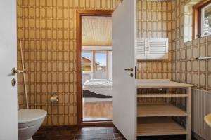 een badkamer met een wastafel en een toilet en een slaapkamer bij Cozy Holiday Home In Thisted in Thisted