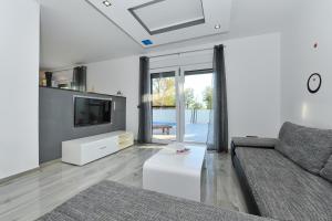 a living room with a couch and a tv at Villa Lily in Privlaka