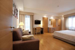 Habitación de hotel con cama y sala de estar. en Hotel Campiello, en San Giovanni al Natisone