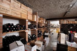une salle remplie de nombreuses bouteilles de vin dans l'établissement Hotel Campiello, à San Giovanni al Natisone