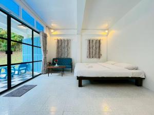 een slaapkamer met een bed, een tafel en ramen bij Today Sunset ที่พักวังน้ำเขียว in Ban Nong Chaeng