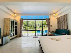 een slaapkamer met een bed en een groot raam bij Today Sunset ที่พักวังน้ำเขียว in Ban Nong Chaeng