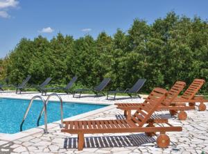 een groep stoelen naast een zwembad bij Sobe Melada in Trilj