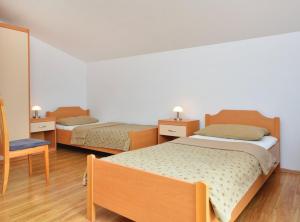 een slaapkamer met 2 bedden en een stoel bij Sobe Melada in Trilj +4 foto's