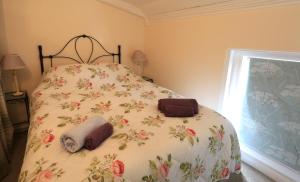 1 dormitorio con 1 cama con colcha de flores en The Old Chapel, en Arundel