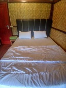 een bed met twee kussens erop bij meta bungalow in Senaru