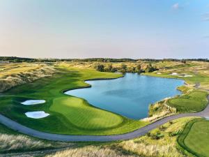 een luchtzicht op een golfbaan met een meer bij Novotel Saint-Quentin en Yvelines in Magny-les-Hameaux