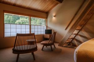 ein Zimmer mit zwei Stühlen und einem Schreibtisch mit Computer in der Unterkunft Kasan in Kirishima