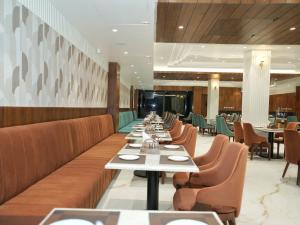 una fila di tavoli e sedie in un ristorante di Hotel Malsi Mist a Dehradun