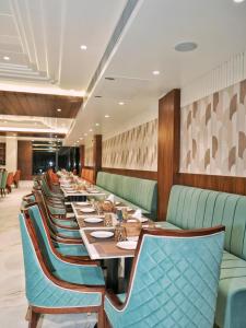 una lunga sala da pranzo con un lungo tavolo e sedie di Hotel Malsi Mist a Dehradun