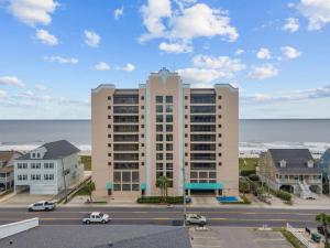 a large apartment building with the ocean in the background at Oceanfront 1BR Condo with Corner Balcony Pool in Myrtle Beach