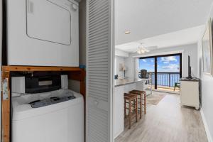 a kitchen and living room with a view of the ocean at Oceanfront 1BR Condo with Corner Balcony Pool in Myrtle Beach
