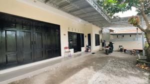 una motocicletta parcheggiata accanto a un edificio con porte nere di Teem Living Jogja a Jejeran