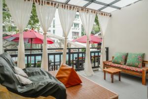 een woonkamer met een balkon met parasols bij Phuvaree Resort in Patong Beach