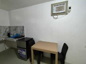 a small room with a table and a air conditioner at Lorna's Home in Panglao Island
