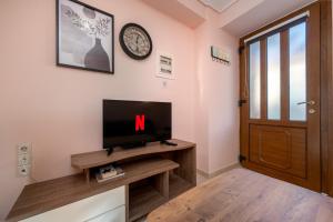 a room with a tv and a clock on the wall at Mytilene Central Home 2 in Mytilini