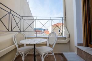 a table and two chairs in a room with a window at Mytilene Central Home 2 in Mytilini