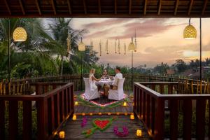 Een bruid en bruidegom zitten aan een tafel op een brug. bij Anumana Village Ubud in Ubud +90 foto's
