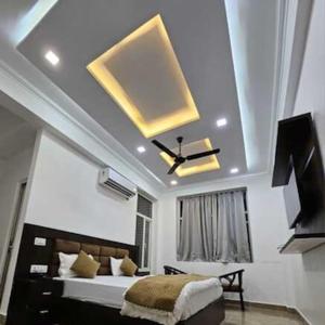a bedroom with a large bed and a yellow ceiling at The Inspira Hotel Haridwar in Haridwār