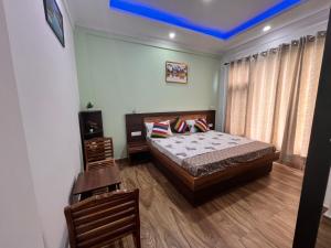 a bedroom with a bed and a blue ceiling at Baldeyan Breeze - 2BHK Apartments - Private Balcony in Shimla