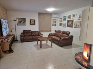 - un salon avec deux canapés en cuir et une cheminée dans l'établissement Villa Dubravka, à Kladje 28 autres photos