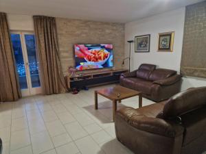 un salon avec un canapé et une télévision dans l'établissement Villa Dubravka, à Kladje