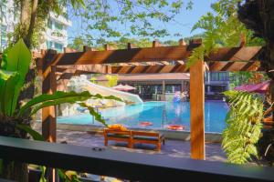 een zwembad met een glijbaan en een bankje bij Phuvaree Resort in Patong Beach