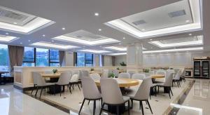een grote kamer met tafels, stoelen en ramen bij Vienna Hotel Hunan Changsha Gaoling in Changsha