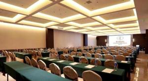 een conferentieruimte met groene tafels en stoelen en een scherm bij Vienna Hotel Hunan Changsha Gaoling in Changsha