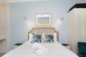 a bedroom with a bed with white sheets and pillows at Unit 133 Amaroo Standard Twin Studio Apartment in Nelly Bay +1 photo