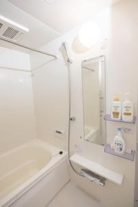 a bathroom with a tub and a sink and a mirror at Ikebukuro House-TS0378 in Tokyo +12 photos