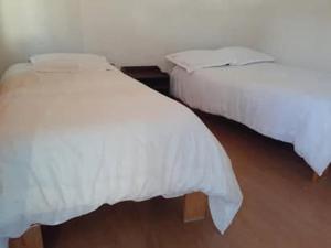 2 bedden met witte dekens in een kamer bij Hotel Gauri Inn Charikot in Dolakhā
