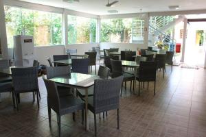 a dining room with tables and chairs and windows at Pousada Canto do Sabiá - Pirenópolis in Pirenópolis