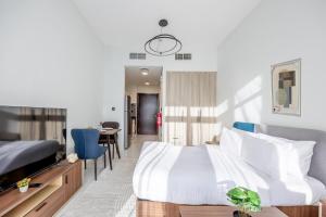 阿布扎比Bloomfields Iconic Studio at The Gate, Masdar City的一间带床的卧室和一间餐厅