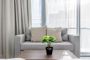 阿布扎比Bloomfields Iconic Studio at The Gate, Masdar City的客厅里有一张沙发和一张摆着植物的桌子