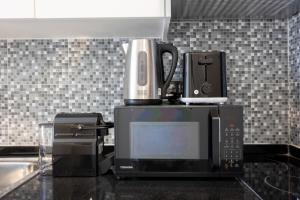 阿布扎比Bloomfields Iconic Studio at The Gate, Masdar City的厨房台面上，微波炉上面放着一台咖啡机。 更多6张照片