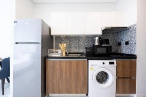 阿布扎比Bloomfields Iconic Studio at The Gate, Masdar City的厨房配有洗衣机和冰箱。