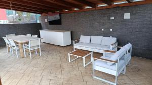 een patio met een bank, stoelen en een tafel bij Casa Ambite in Ambite