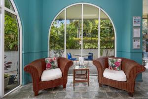 two chairs and a table in a room with windows at Unit 133 Amaroo Standard Twin Studio Apartment in Nelly Bay
