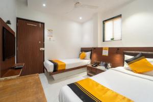 a hotel room with two beds and a television at Itsy Hotels Rexton Inn in Mumbai +26 photos