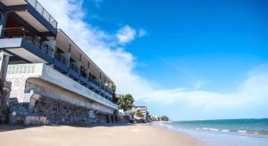 ein Gebäude am Strand neben dem Meer in der Unterkunft Phala Shore Resort in Ban Phala