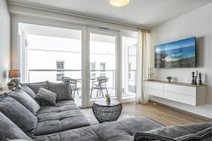 a living room with a couch and a large window at Seeluft Olpenitz in Olpenitz