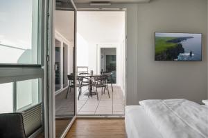 a bedroom with a bed and a balcony with a table at Seeluft Olpenitz in Olpenitz