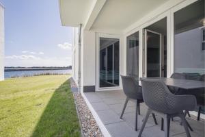 a patio with a table and chairs on the side of a house at Ostseebrise Olpenitz in Olpenitz