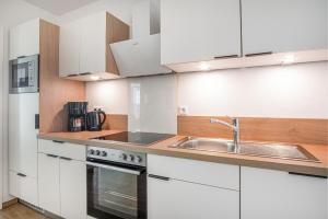 a kitchen with white cabinets and a sink at Ostseebrise Olpenitz in Olpenitz
