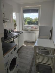 een keuken met een wasmachine en een raam bij Ganze Wohnung mit privatem Balkon in Gelsenkirchen