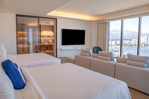 ein Hotelzimmer mit zwei Betten und einem Flachbildfernseher in der Unterkunft Homm Marina Sokcho in Sokcho