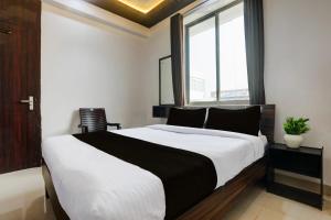 een slaapkamer met een groot bed en een raam bij HOTEL O MJ INN in Darbhanga +20 foto's