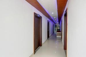 DarbhangaHOTEL O MJ INN的医院的走廊,有木门和白色墙壁 更多20张照片